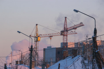 Large construction site with construction cranes and tall houses