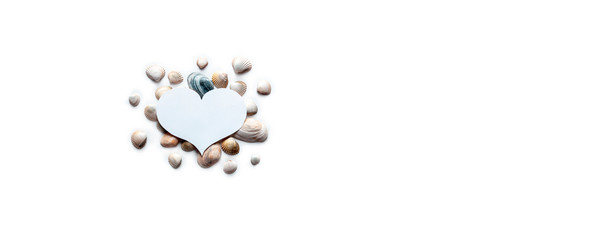 on a white background under a white heart a gift for Valentine's Day different beautiful sea shells in the form of postcards with a copy space