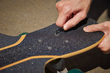 A man customizing skateboard outdoor 