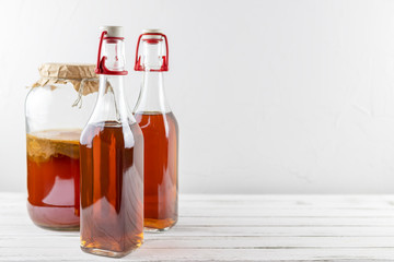 Kombucha superfood pro biotic tea fungus beverage in glass bottle and jar on white background