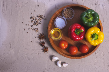 tomatoes, paprika and spices, lie on a table and a wooden tray