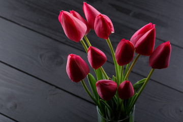 pink tulips on a black wooden table