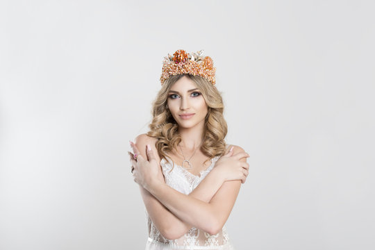 Confident smiling crowned woman bride miss beauty queen holding hugging herself isolated white wall background. Positive human emotion facial expression feeling reaction attitude Love yourself concept