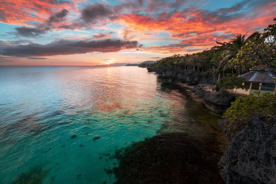 Amazing philippine sunset on island bohol anda. turquoise water palm tree coconut tree purple sky