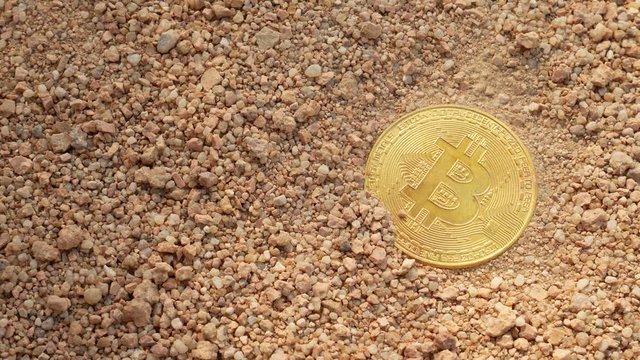 Bitcoin on the sand by the sea at the summer day