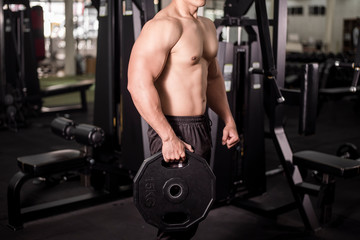 Fototapeta na wymiar Muscular fitness man bodybuilder is workout in gym