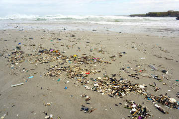 Low tide shows plastics and rubbish over the sand of a beach in As illas beach, Ribadeo, Lugo, Galicia, Spain