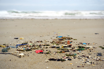 Fototapeta na wymiar Low tide shows plastics and rubbish over the sand of a beach in As illas beach, Ribadeo, Lugo, Galicia, Spain