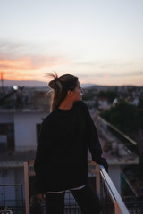 Fototapeta premium Woman admiring sunset from her balcony