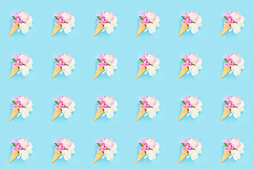 Peonies flowers bouquet in waffle ice cream cone on light blue background. Seamless pattern. Summer concept.