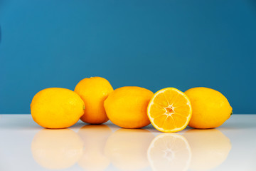 Yellow ripe lemon sliced in half juicy citrus fruit on the white table in front of the blue...