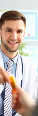 Obraz premium Portrait of smiling doc man wearing white robe and stethoscope. Physician talking with visitor about state of health. Medical treatment and healthcare concept. Blurred background