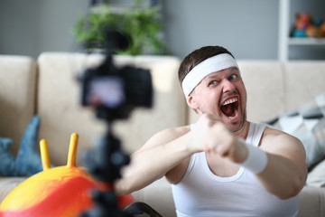 Screaming Vlogger Recording Boxing Video on Camera. Bearded Man Shooting Workout on Digital Camcorder for Fitness and Aerobic Vlog. Sportsman Doing Warmup Exercise for Hands Indoor Photography