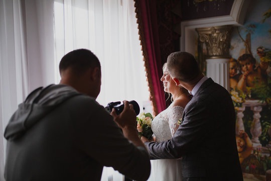 wedding photographer taking pictures of the bride and groom on classic interior