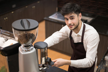 Portrait smiling and happy man with his job.Handsome young man barista making coffee with coffee machine at counter coffee shop.