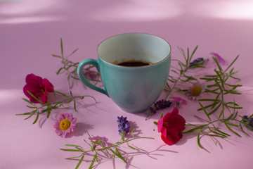 cup of coffee  with flowers on pink background 