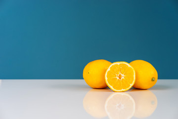 Yellow ripe lemon sliced in half juicy citrus fruit on the white table in front of the blue background wall fresh fruits