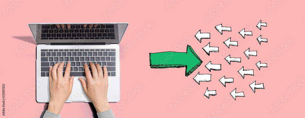 Poster arrow going in the opposite direction with person using a laptop computer