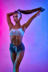 Sporty girl holding ponytail in studio.