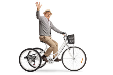 Senior man riding a tricycle and waving at the camera