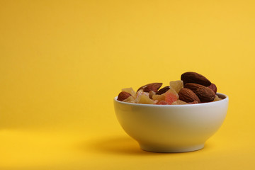 a bowl of fruit mix isolated on yellow background. Healthy eating concept