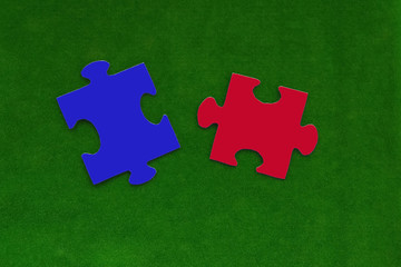 Puzzles in blue and red on a green background. component. business, interaction.