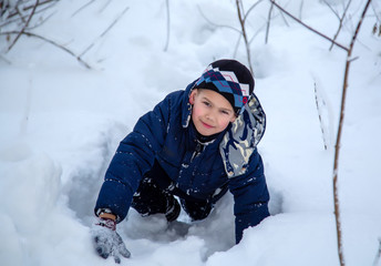 Fototapeta na wymiar portrait of a boy crawling in the snow