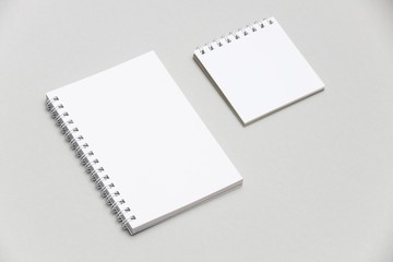 Blank notepad isolated on grey background to replace your design. Two blank notepads on gray background to replace your design. Side view