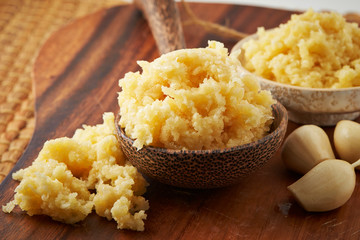 Grated garlic on wooden board and spoon