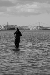 Fototapeta na wymiar Fisherman Fishing alone in Tagus River, Black and White