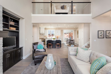 Beautiful living room and kitchen in new home with open concept floor plan. Shows second story landing area with railing. 