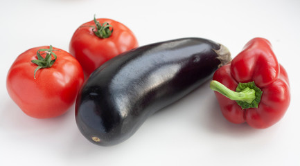 Vegetables eggplant, bell pepper and tomatoes on a white background