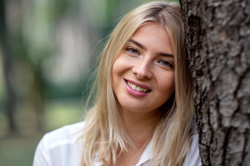 Portrait of young blonde girl in park