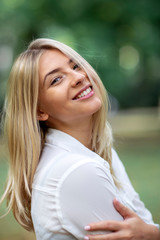 Portrait of young blonde girl in park