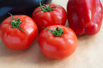 Vegetables eggplant, bell pepper and tomatoes on a paper background