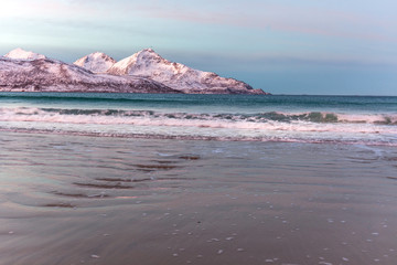 Fototapeta na wymiar Amazing sunrise with amazing magenta color over sand beach. Tromso, Norway . Polar night. long shutter speed