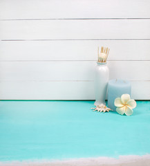 Interior decoration of a house, flowers, candle, sea shell, soap and vase on white wood and mint background. Modern interior. Minimalism style.