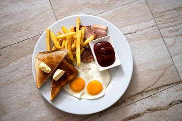 Fried eggs with toast and french fries for breakfast