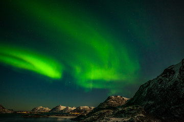 Fototapeta na wymiar aurora borealis , amazing northern lights over the mountains in the North of Europe - Lofoten islands, Norway