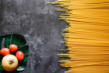 Yellow long spaghetti on a rustic background. Yellow italian pasta. Long spaghetti. Raw spaghetti...