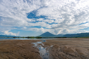 Pink lesser Flamingos at Lake Natron with Ol Doinyo Lengai volcano on background in Rift valley, Tanzania