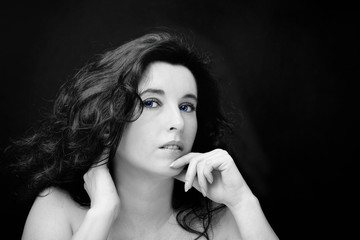 Fototapeta premium Young attractive woman with long black hair on dark background