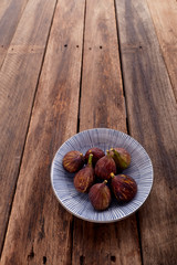 figs on plate on wooden table background
