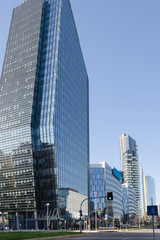 Naklejka premium Skyscrapers by the road against a clear blue sky
