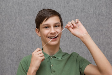 teenager with braces and flossing