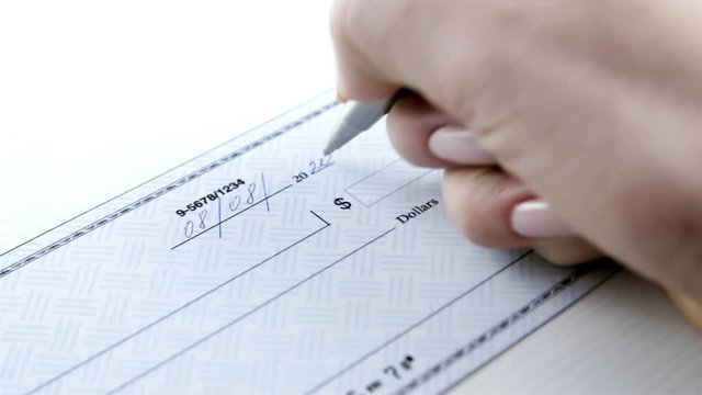 Business woman prepare writing a check. Paycheck concept. Payment by cheque