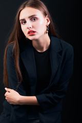Fototapeta na wymiar Young beautiful girl posing in studio dressed in a black jacket.