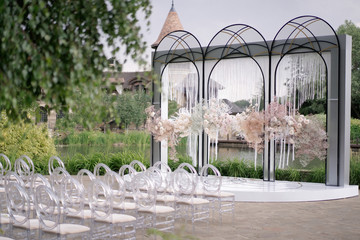 Beautiful blooming pink roses and baby's breath decorate the arch for the wedding ceremony. Luxury...