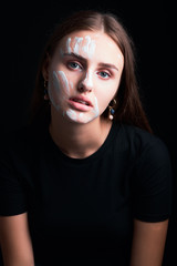 Art portrait of a beautiful girl in white paint.