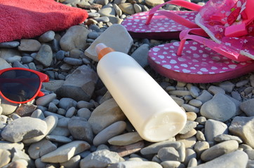 Beach items for resort flat lay. Top view, things for swimming and relaxation, sunbathing on the beach on the beach. Large, etched raspberry hat, towel, sunglasses, sunblock